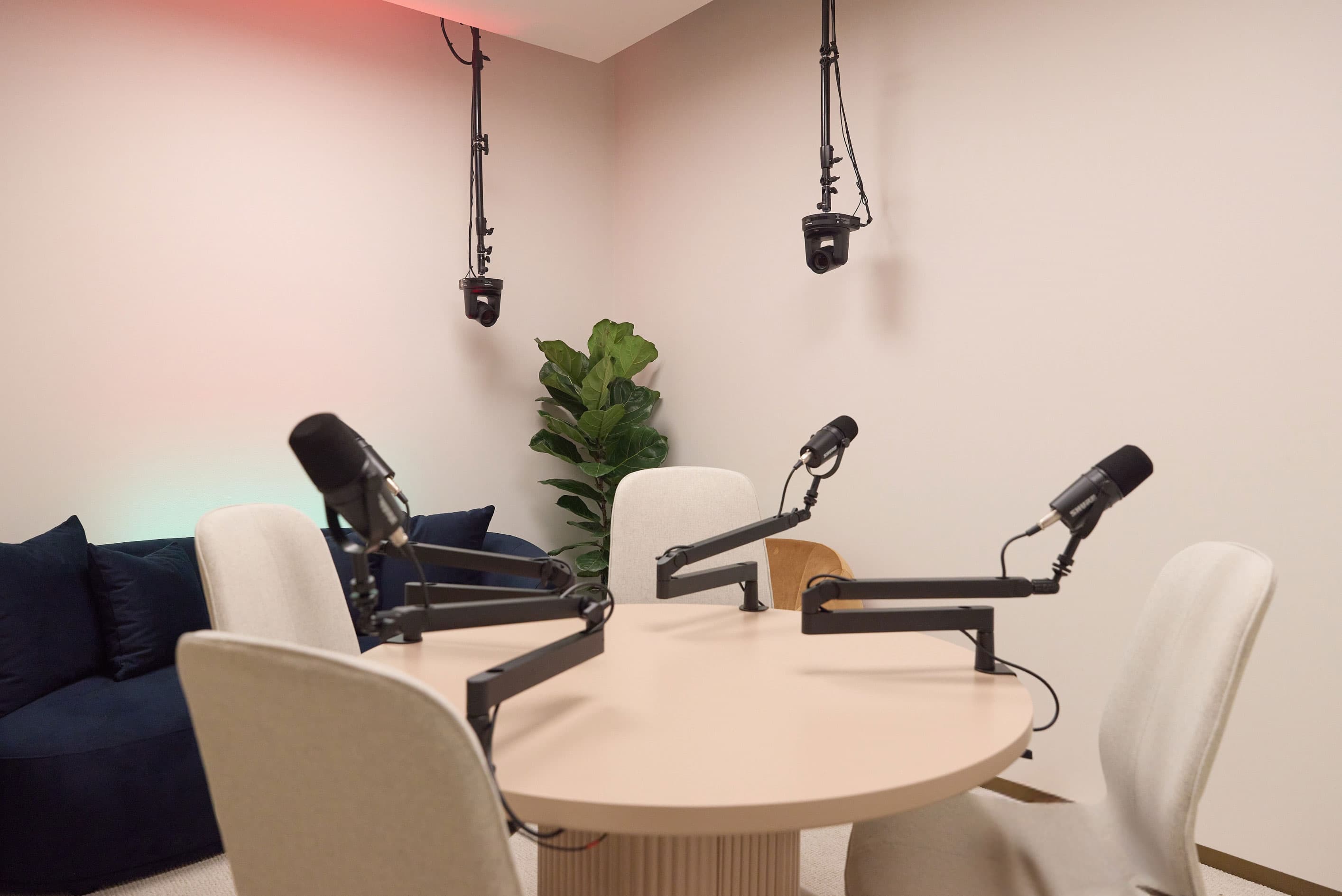 Interior space of Talent Studios with four microphones on a table and a sofa